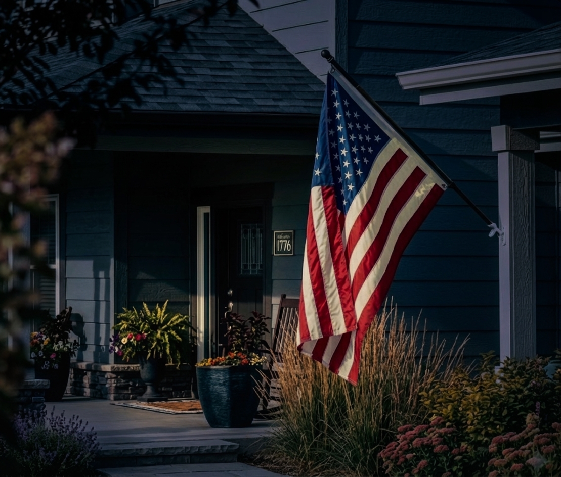 Veranda eines Hauses mit gehisster US-Flagge, Blumentöpfen und Eingangsbereich